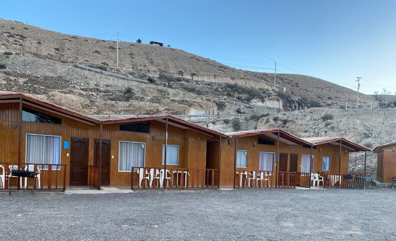 Cabañas de madera de Ayni Munay junto a los cerros de Mamiña