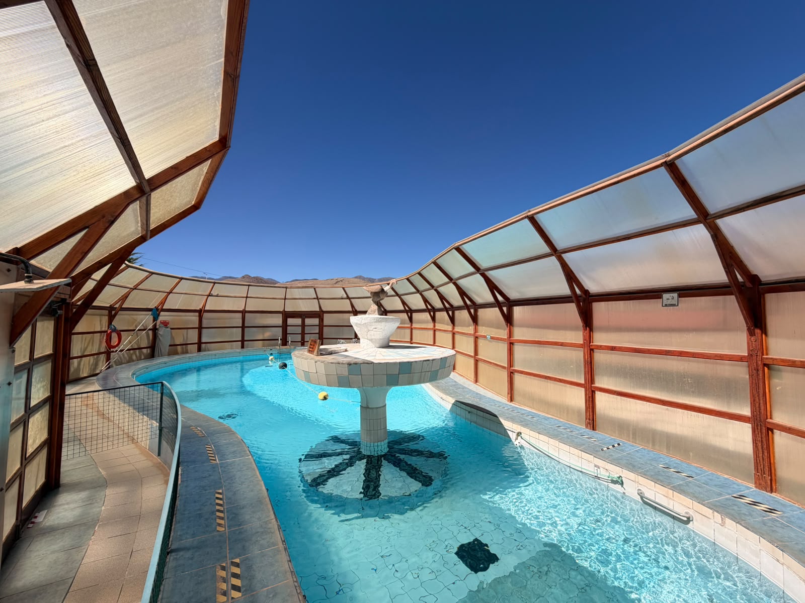 Piscina del hotel con agua celeste y fuente central